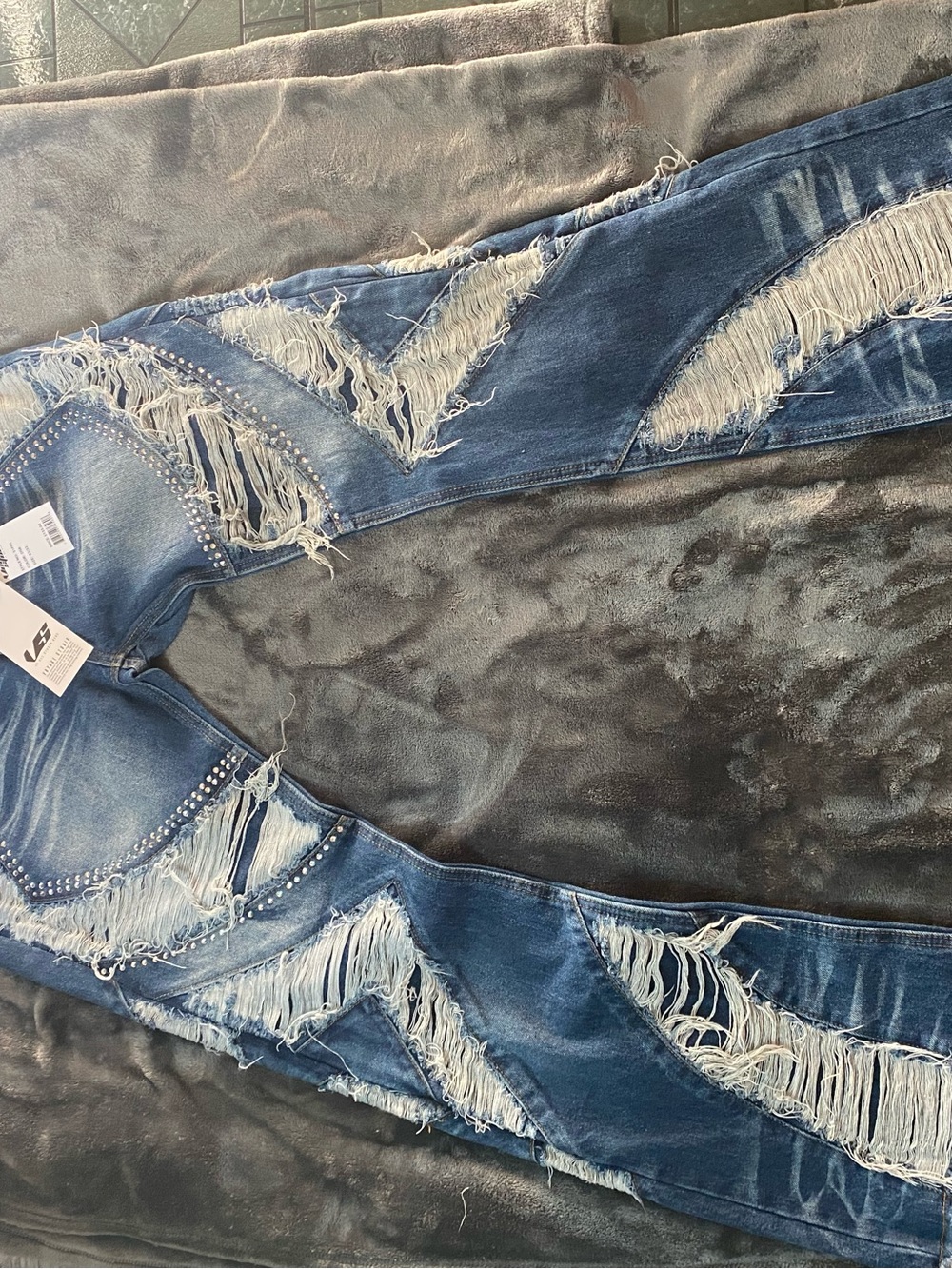 Slim fit jeans with distressed fringe and studs with extra wide leg